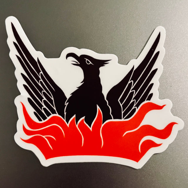Image of a sticker that is die cut and shows a dark brown phoenix and reddish flames below.
